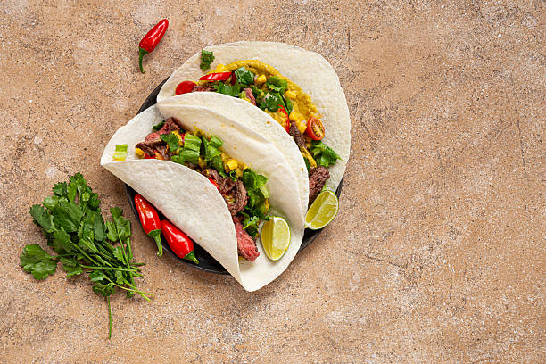 istock Mexican tacos with beef, tomatoes, vegetables, chilli and onions on light background top view copy space for text 2233519912