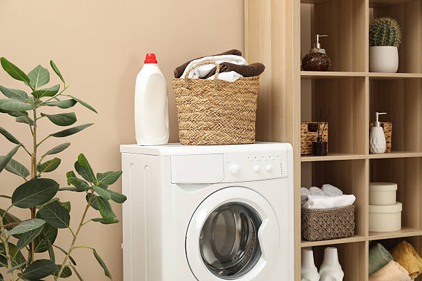 istock Wicker basket full of laundry, washing machine and detergent in bathroom 2233520405