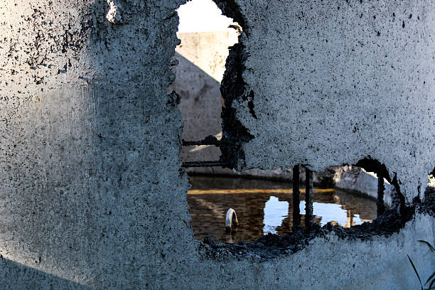 istock a precast concrete structure with a hole, exposing rebar and standing water. 2233522984