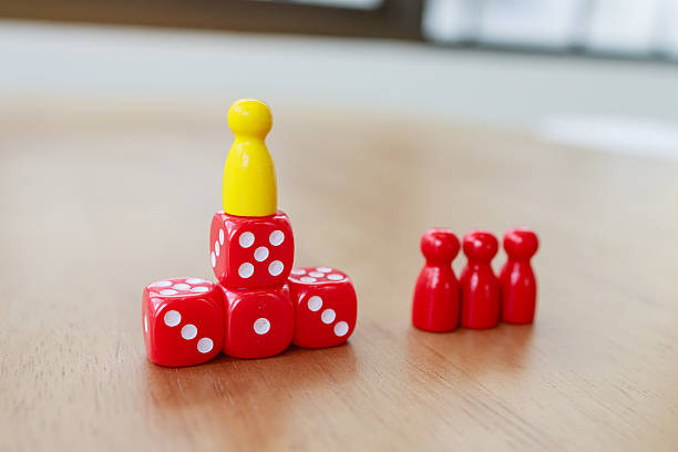 istock Leadership and authority concept with a single figure standing on stacked dice, separated from red group figures, symbolizing power, hierarchy, distance, and team dynamics 2233523423