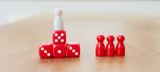 istock Leadership and authority concept with a single figure standing on stacked dice, separated from red group figures, symbolizing power, hierarchy, distance, and team dynamics 2233523435