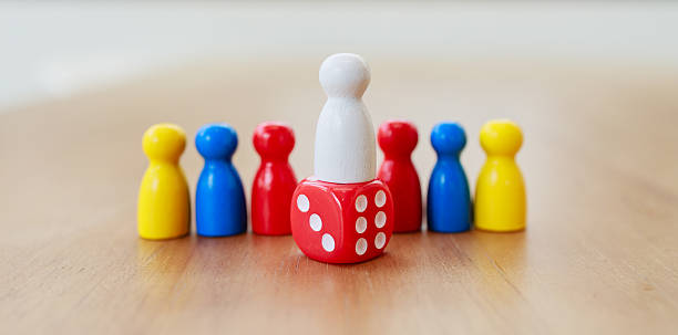 istock Leadership and decision-making concept with a white leader figure standing on dice, symbolizing risk, responsibility, and guiding a diverse team towards shared success 2233523437