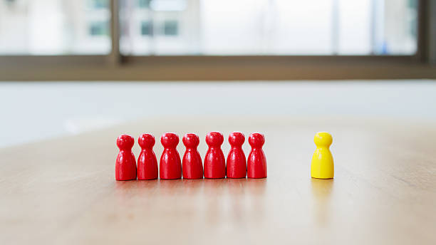 istock Leadership and teamwork concept showing individuality and influence, A single yellow leader figure stands apart, guiding and inspiring a unified team represented by red figures 2233523463
