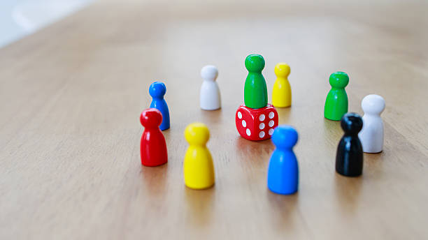 istock Leadership and teamwork concept illustrated by a central pawn standing on a red dice, surrounded by colorful pawns, symbolizing risk, decision making, and collective strategy 2233523464