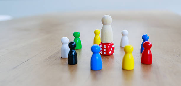 istock Leadership and teamwork concept illustrated by a central pawn standing on a red dice, surrounded by colorful pawns, symbolizing risk, decision making, and collective strategy 2233523465