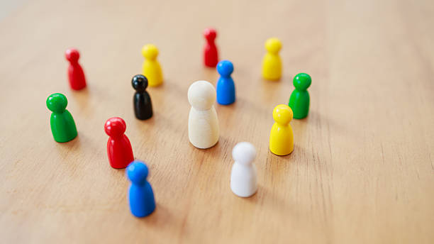 istock symbolizing leadership, teamwork, diversity, inclusion, communication, and unity in community or business concept, Wooden figure standing at the center surrounded by colorful figures 2233523723