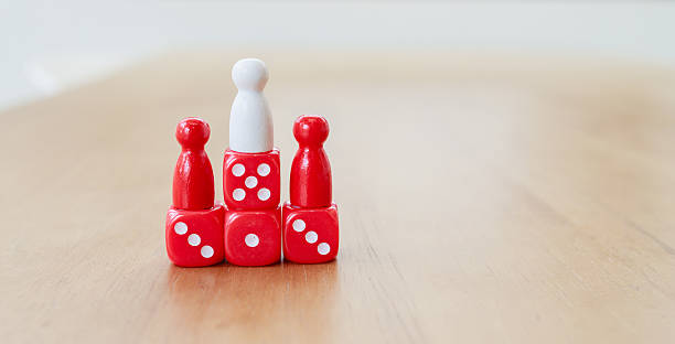 istock Teamwork and leadership concept with white and red figures standing together on stacked dice, symbolizing unity, balance of power, shared leadership, and collective responsibility 2233523760