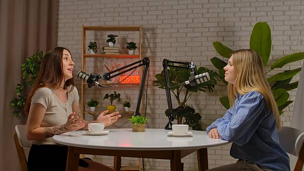 Two women recording podcast in modern studio