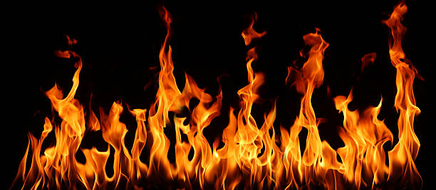 istock Orange fire flames burning isolated on black background, abstract texture symbolizing heat, energy, danger, and power, perfect for design, advertising, safety concepts, and dramatic backgrounds. 2233524844