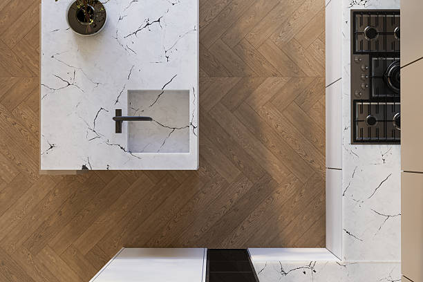 istock Modern kitchen top view. Marble island with black faucet and herringbone wood floor create a minimalist, elegant interior. Perfect for mock-up or design use. 3D render. 2233525176