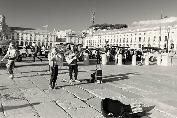 Lisbon, Portugal - November 2, 2024: A couple of street musicians perfom at the Praça do Comércio square in Lisbon downtown.