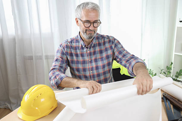 istock Senior Engineer Reviewing Construction Plans At Office Table 2233527859