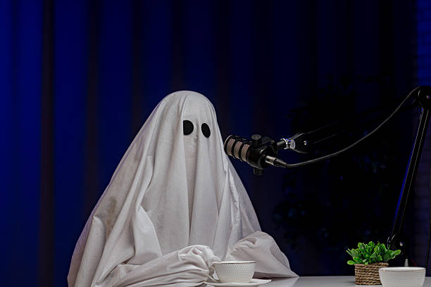istock Ghost costume recording podcast in dark studio 2233528185