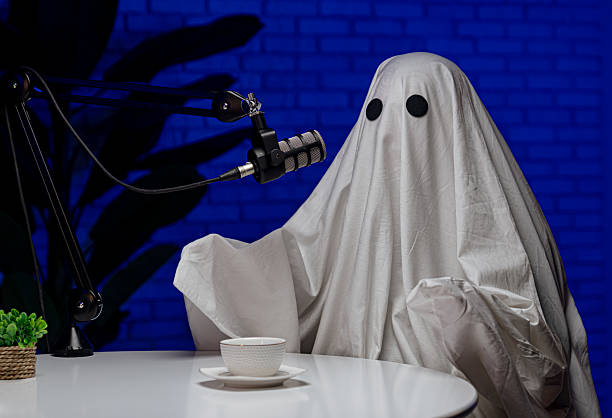 istock Ghost costume recording podcast in dark studio 2233528809