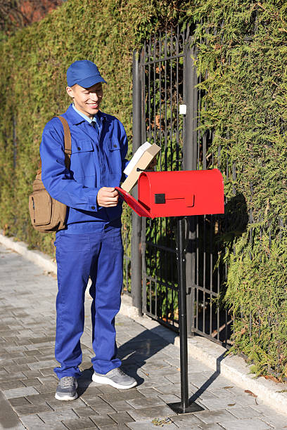 istock Postman putting parcel into mail box outdoors 2233528840