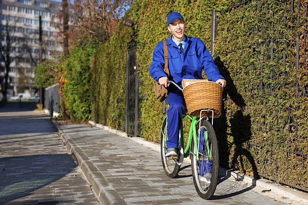 Postman with parcels in bicycle basket outdoors