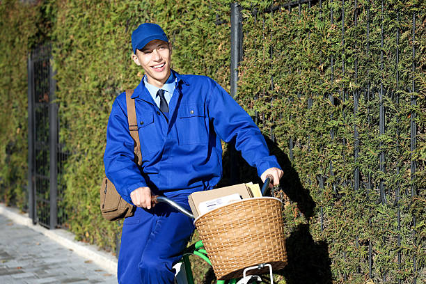 Postman with parcels in bicycle basket outdoors