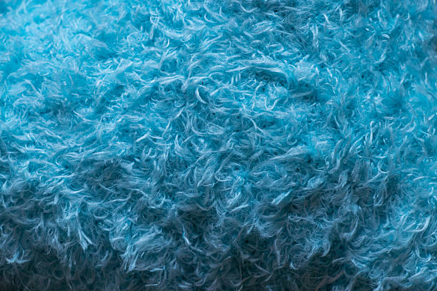 Soft synthetic light blue curly wool as background or wallpaper with fleecy texture and fluffy surface for decorative purposes