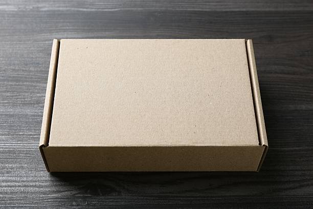 istock One blank cardboard box on wooden background. Mockup for design 2233530214