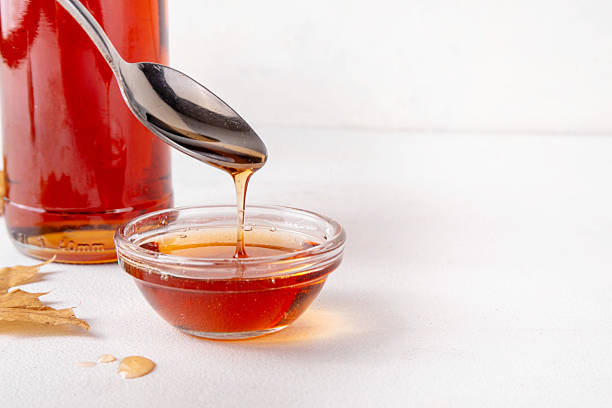 istock Tasty golden maple syrup in bottle, bowl and spoon 2233536611