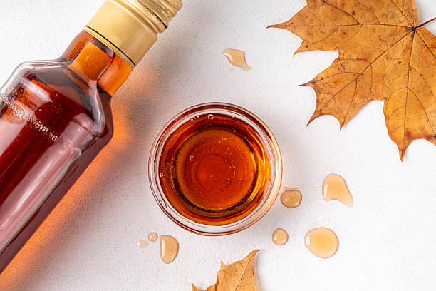 istock Tasty golden maple syrup in bottle, bowl and spoon 2233536672