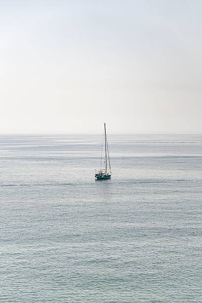 istock Sailing boat floating on calm turquoise sea with clear horizon 2233540689