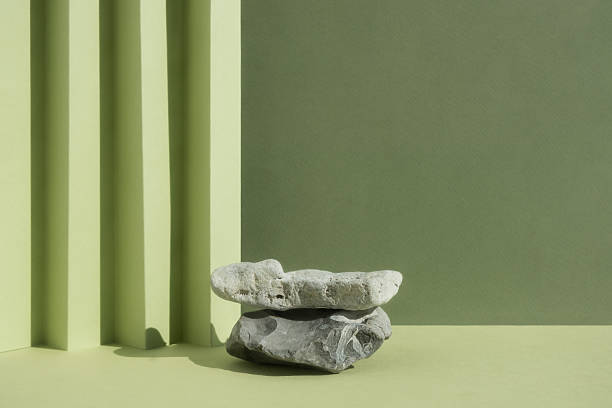 istock Empty podium made of gray stones on a green background. Scene with a geometric backdrop for the promotion of products, beauty, natural eco-cosmetics. Showcase, display case. 2233540745