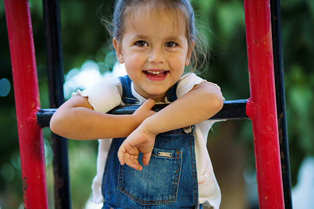 Cute little girl is standing on the slide.