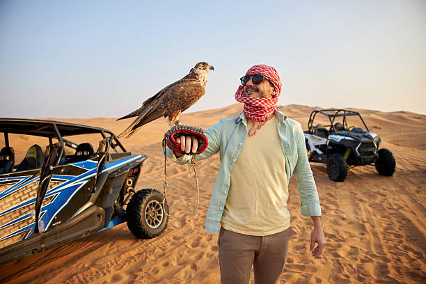 istock Handsome man holding falcon in Dubai desert 2233541223
