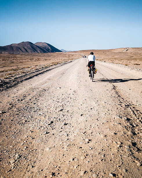 istock Bikepacker rides remote rural roads 2233544569