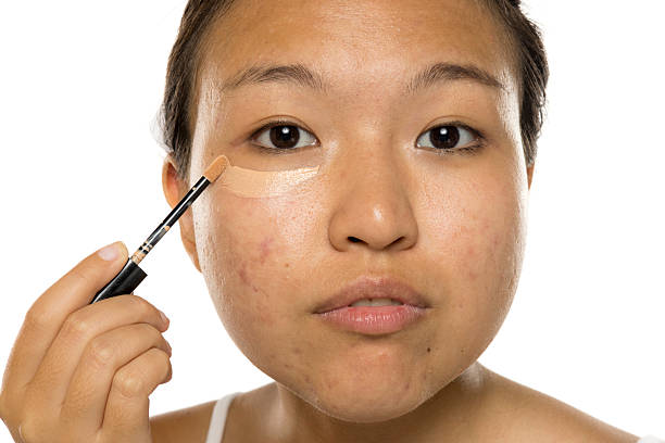 young asian woman apply concealer under the eye