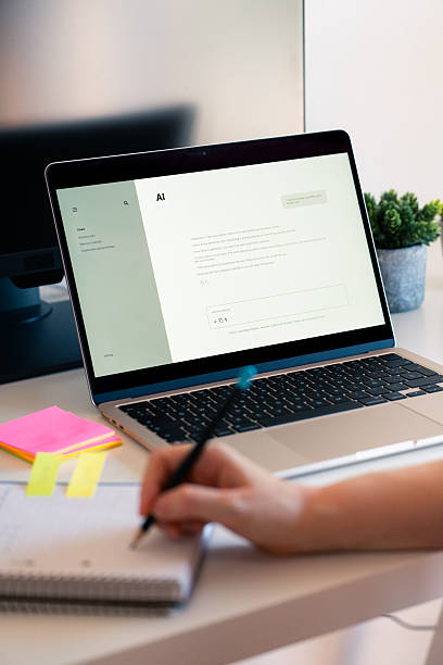 istock Person uses AI chat on a laptop while taking notes at a desk with colorful sticky notes 2233546720