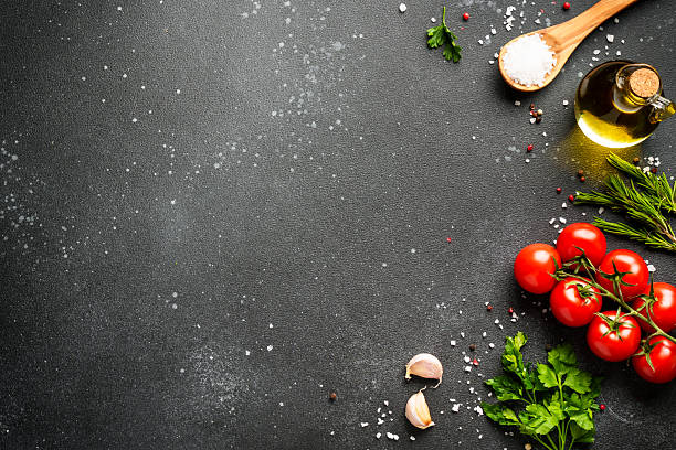 istock Food background with fresh vegetables, herbs and spices on black. 2233546872