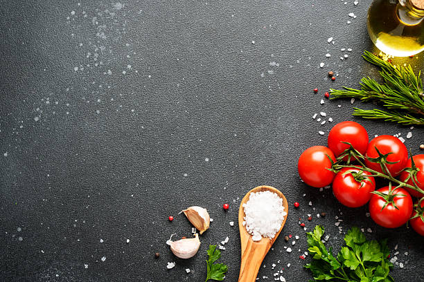istock Food background with fresh vegetables, herbs and spices on black. 2233546888