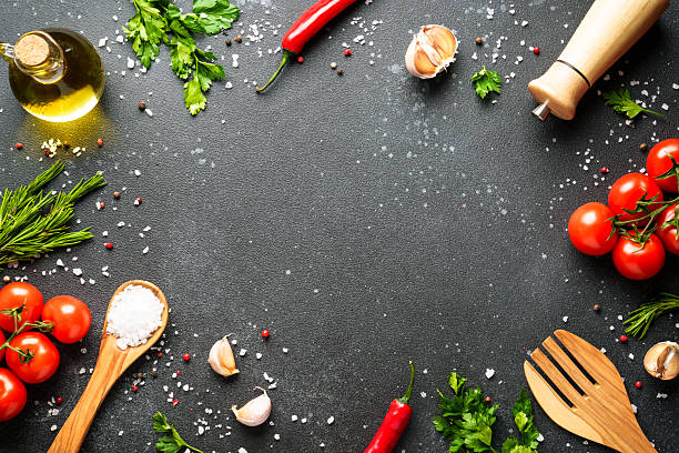 istock Food background with fresh vegetables, herbs and spices on black. 2233546912