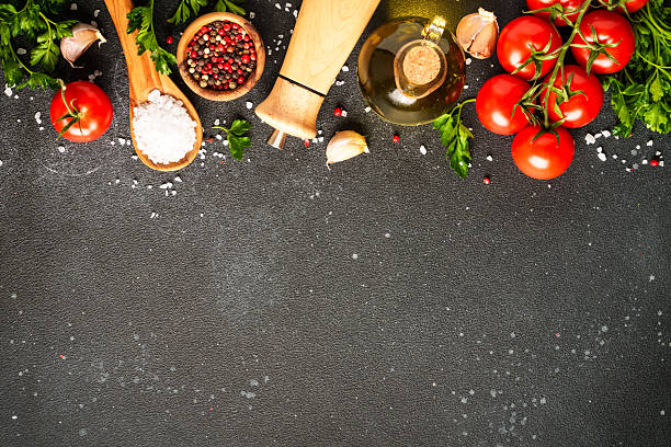 istock Food background with fresh vegetables, herbs and spices on black. 2233546969