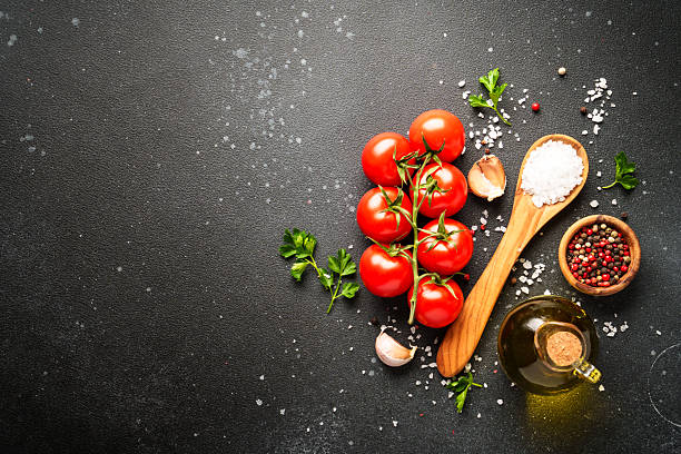 istock Food background with fresh vegetables, herbs and spices on black. 2233547074