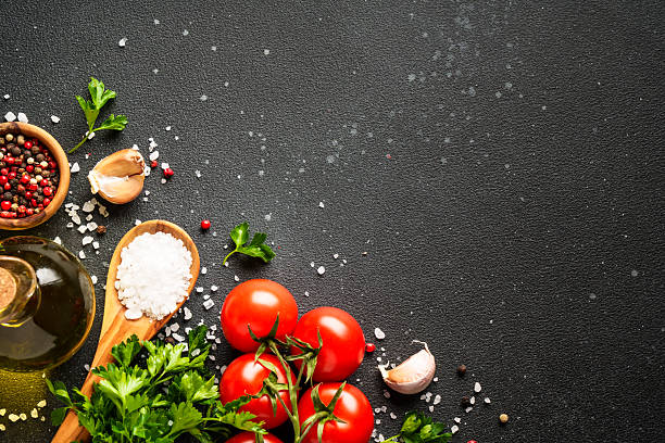 istock Food background with fresh vegetables, herbs and spices on black. 2233547076