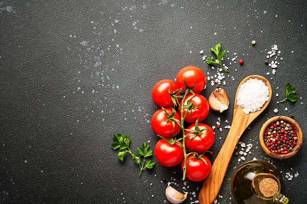 istock Food background with fresh vegetables, herbs and spices on black. 2233547077