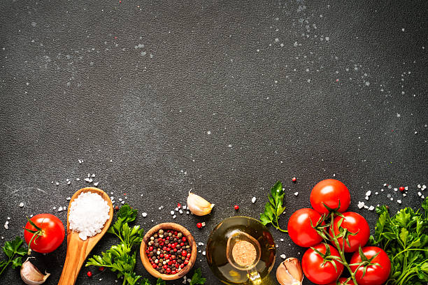 istock Food background with fresh vegetables, herbs and spices on black. 2233547078