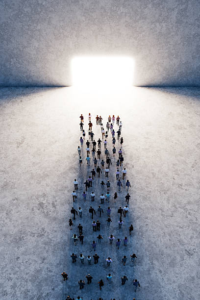 istock Crowd of people walking towards bright light gate in large space 2233547633