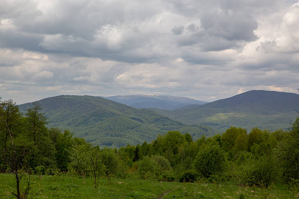 istock Vibrant mountain landscape with forested hills under a dramatic cloudy sky during the day. 2233547722
