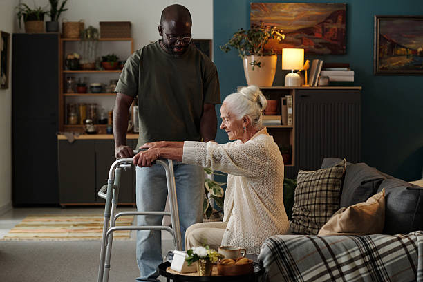 istock Senior Caucasian Woman Using Walker Assisted by Black Man Indoors 2233552273