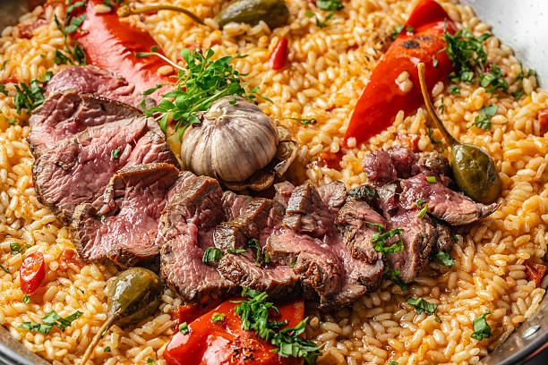 Close-up of paella with beef, peppers, and garlic. top view.