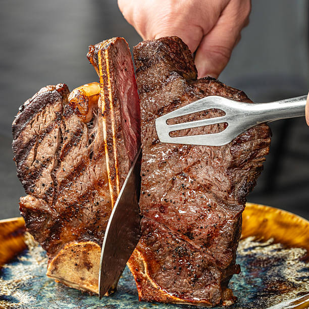 istock Juicy porterhouse steak being sliced in chefs hands 2233552526
