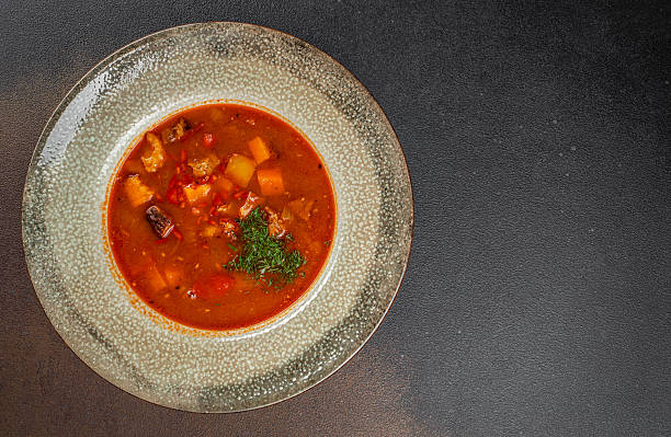 istock Traditional meat soup with vegetables and herbs in a ceramic plate. top view. copy space 2233552542