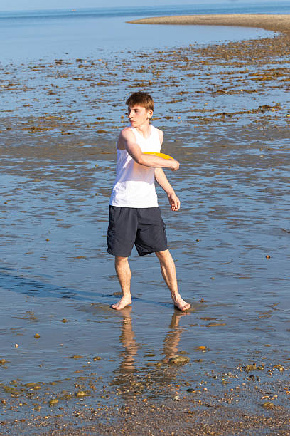 istock Teenage Boy Playing With A Frisbee 2233552545