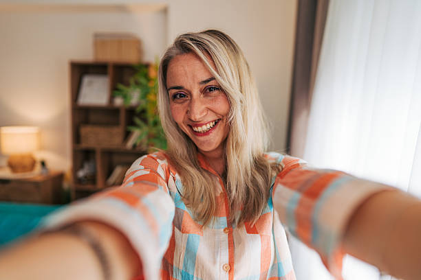 istock Cheerful woman taking a selfie at home, sharing happiness 2233554517