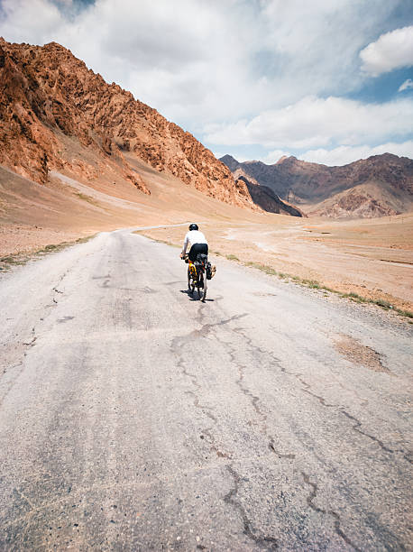 istock Bikepacker rides remote mountain roads 2233554758