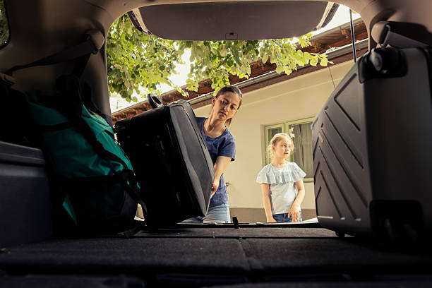 istock Mother and daughter loading their packed car with baggage 2233555557